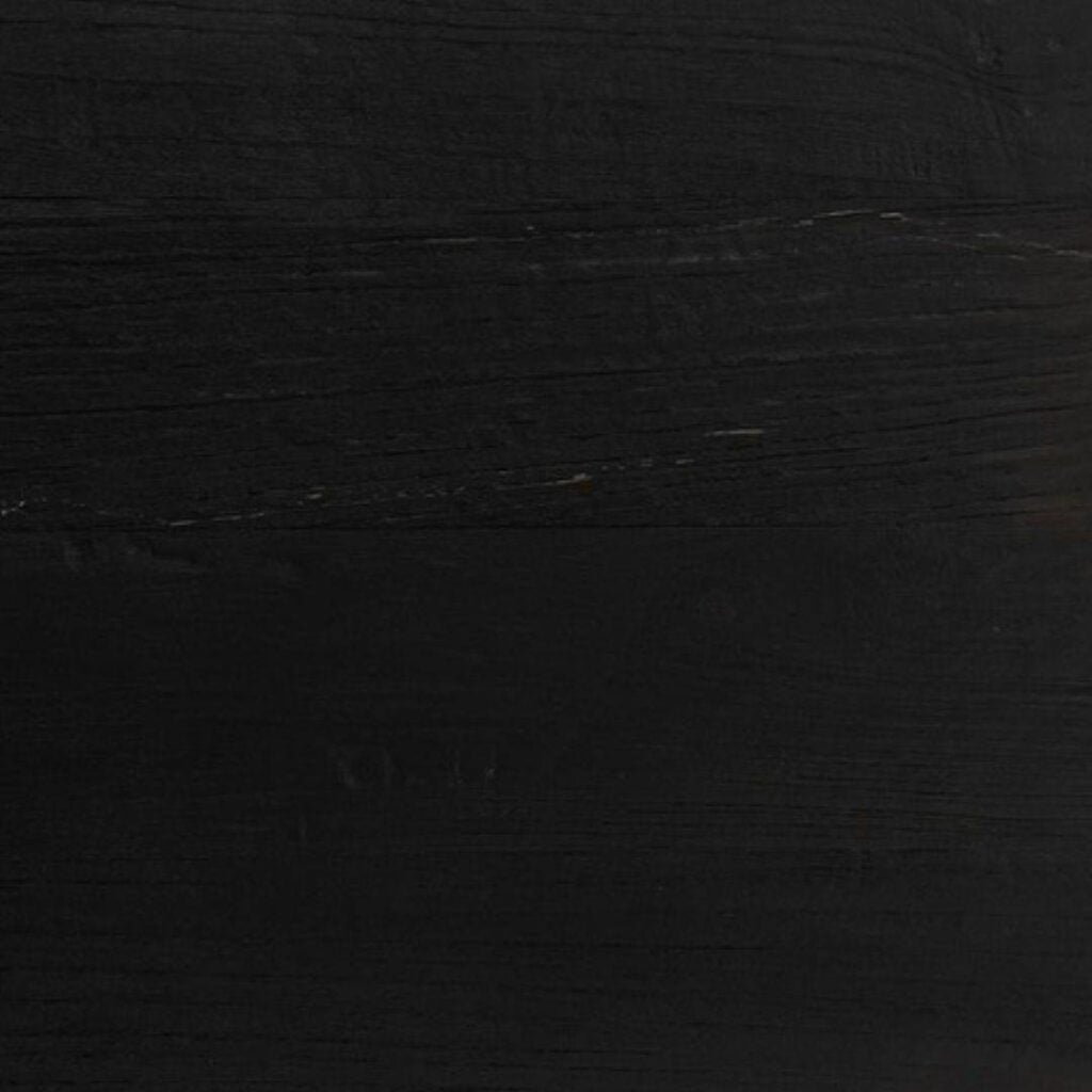 A close-up of a black wooden surface with visible texture and grain patterns.