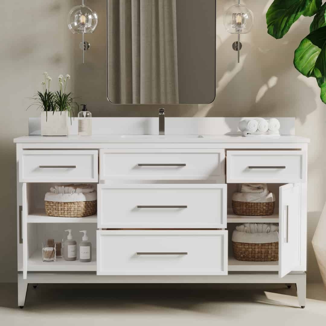 The Barrington 60" Single Sink Bathroom Vanity features a modern white design with a large mirror, drawers, and open shelves. It is adorned with plants, soap dispensers, and rolled towels.