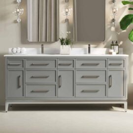 A modern Barrington bathroom vanity with a double sink, large mirrors, grey cabinets, and drawers. The setup includes soap dispensers, white rolled towels, and a potted plant.