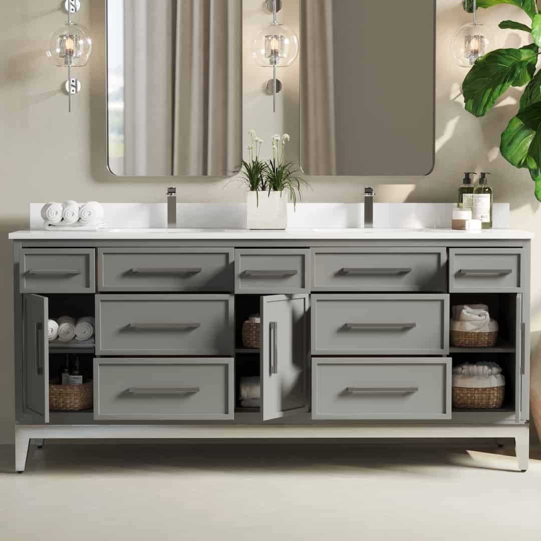 The Barrington Double Sink bathroom vanity features grey drawers and cabinets, mirrored walls, and decorative lighting. Towels, baskets, and toiletries are neatly organized inside and on the countertop, making this espresso-finished piece both functional and stylish.