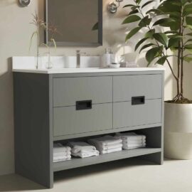 The Delamere 48" Single Sink Bathroom Vanity features a sleek gray cabinet paired with a pristine white countertop, accompanied by an elegant faucet and a spacious mirror. Neatly folded towels are placed on the open shelf below, while a large potted plant adds a touch of greenery to the right.