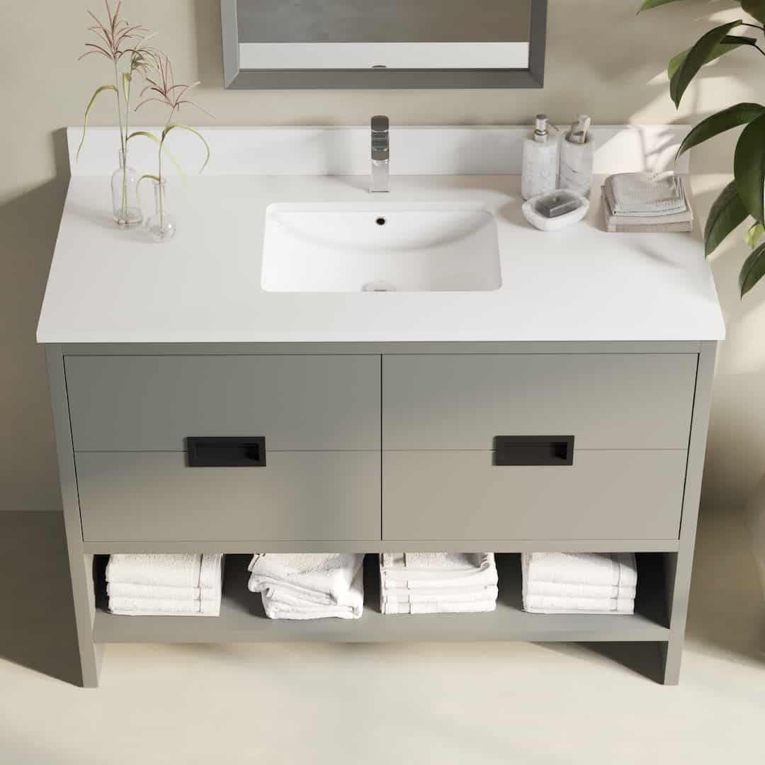 Urban Woodcraft Delamere 48in Single Bathroom Vanity Dark Grey 3 The Delamere 48" Single Sink Bathroom Vanity features a sleek white countertop, an elegant faucet, two spacious drawers, and convenient open shelf storage below that perfectly accommodates folded white towels.