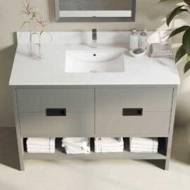 The Delamere 48" Single Sink Bathroom Vanity features a sleek white countertop, an elegant faucet, two spacious drawers, and convenient open shelf storage below that perfectly accommodates folded white towels.