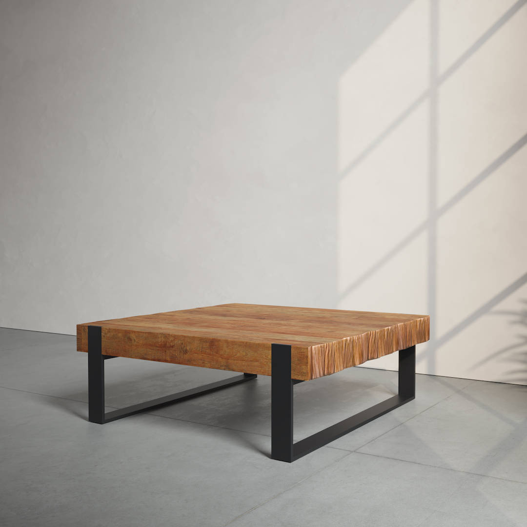 A wooden coffee table with a square top and black metal legs is positioned in a minimalist room with sunlight casting shadows on the wall.
