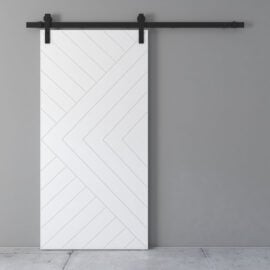 A Lucas 83" x 40" Reclaimed Wood Arrow Barn Door, featuring a chevron pattern and mounted on a black sliding rail system, set against a grey wall and a concrete floor.
