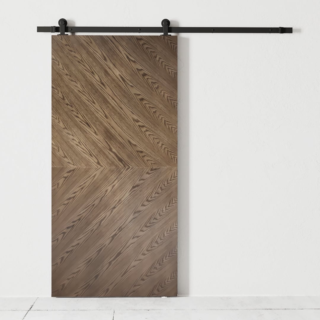 The Lucas 83" x 40" Reclaimed Wood Arrow Barn Door, featuring a herringbone pattern, is mounted on a black metal track against a plain white wall.