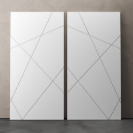 Two Klaus 83" x 40" Geometric Barn Doors with intersecting diagonal lines are positioned side by side against a plain wall on a concrete floor.