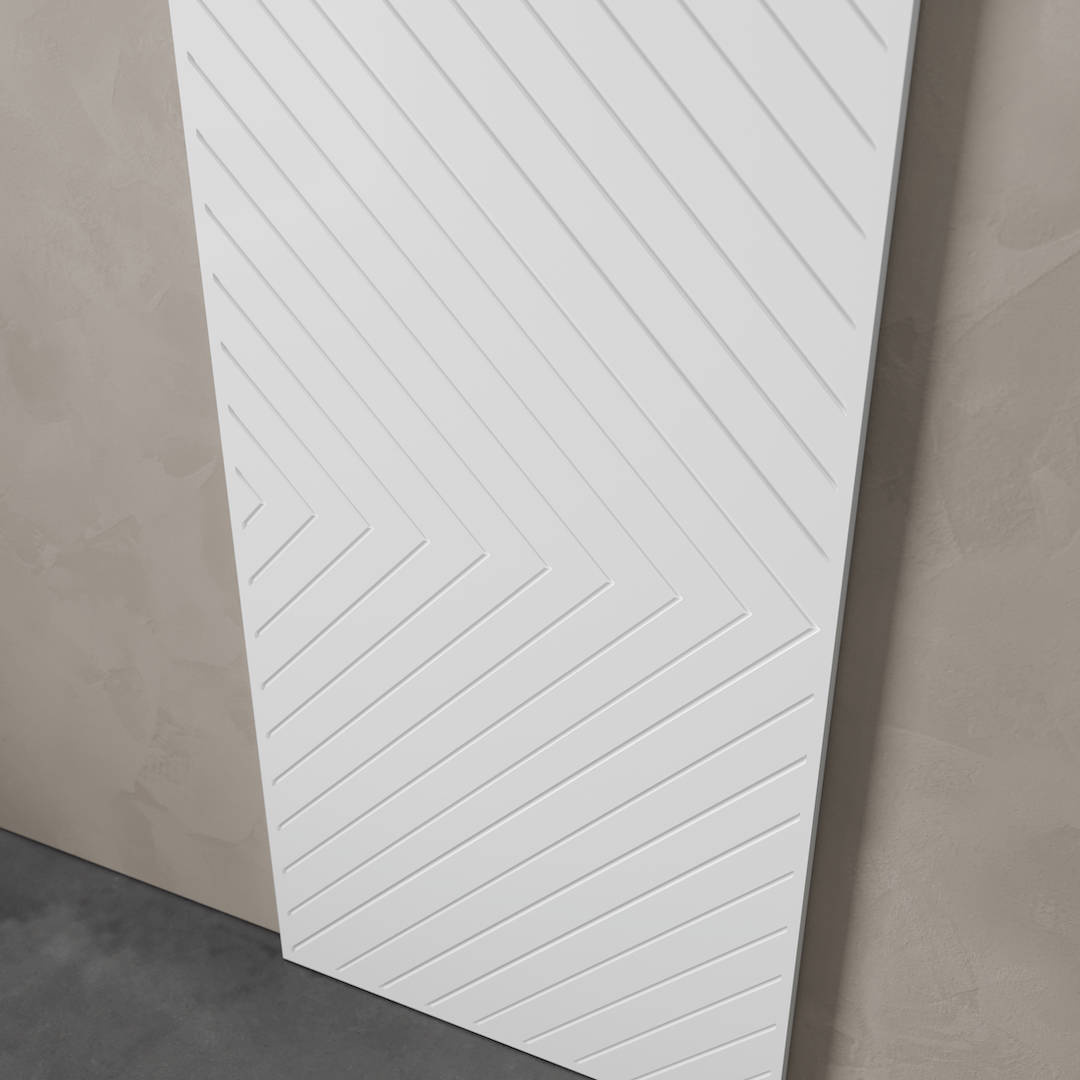 Urban Woodcraft Venice 40in Arrow Barn Door White 3 The Venice 83" x 40" Arrow Barn Door, featuring a white, rectangular design with a zigzag pattern of grooves, is leaning against a light grey textured wall.