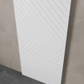 The Venice 83" x 40" Arrow Barn Door, featuring a white, rectangular design with a zigzag pattern of grooves, is leaning against a light grey textured wall.