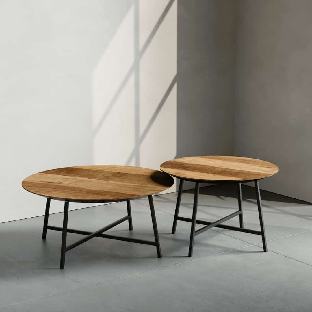 Two 2 Piece Slim Round Coffee Tables with metal legs are positioned on a smooth floor. Light filters through a nearby window, casting shadows on the floor and wall.