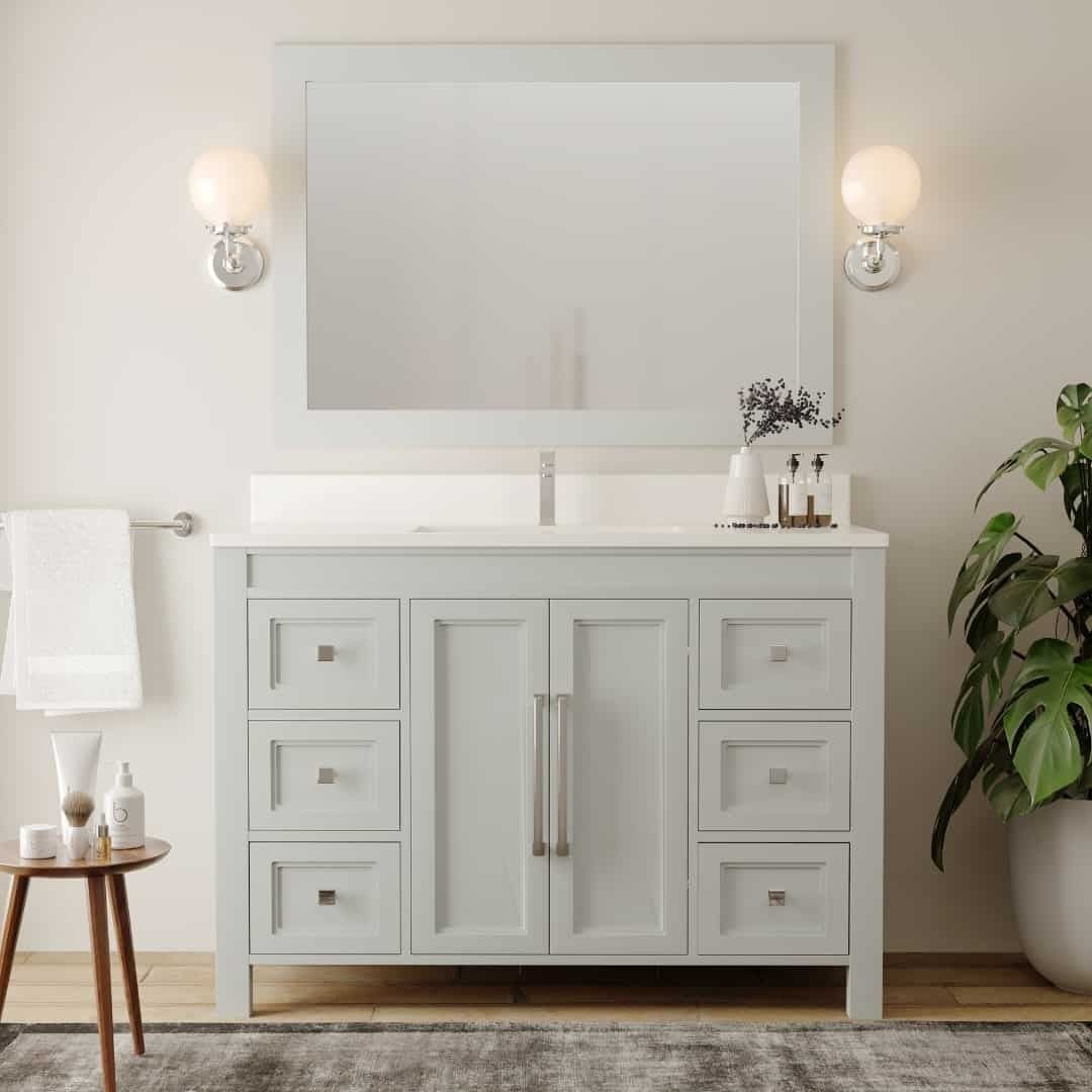 The Belluno 48" Single Sink Vanity in modern white is complemented by a large mirror, twin wall sconces, a potted plant, and a small side table with toiletries.