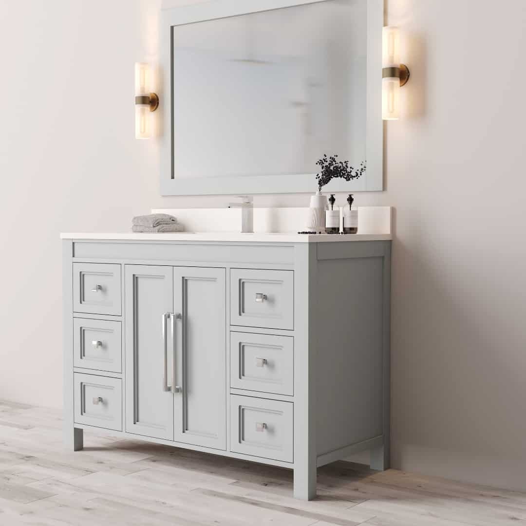 48_ Single Sink Belluno Vanity (Grey) - 3 The Belluno 48" Single Sink Vanity features a modern design with a large mirror, two wall-mounted lights, a small plant, and toiletries arranged on the counter. It boasts multiple drawers and comes in a light gray finish.