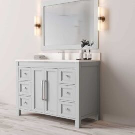 The Belluno 48" Single Sink Vanity features a modern design with a large mirror, two wall-mounted lights, a small plant, and toiletries arranged on the counter. It boasts multiple drawers and comes in a light gray finish.