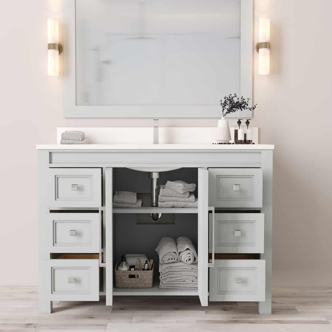 The Belluno 48" Single Sink Vanity features a large mirror, light fixtures, multiple shelves and drawers, neatly folded towels, a potted plant, and a basket with toiletries underneath the sink.