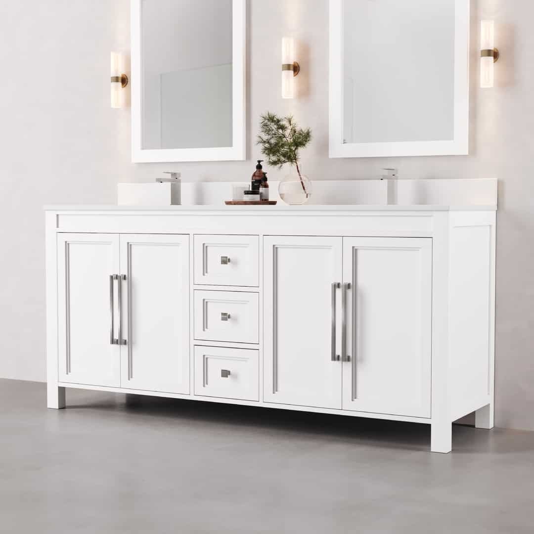 72_ Double Sink Belluno Vanity (White) - 2 The Belluno 72" Double Sink Vanity features a modern design with a sleek double white sink, two expansive mirrors, elegant silver hardware, and two wall-mounted lights. The countertop is adorned with a small plant and a soap dispenser, enhancing the sophisticated look. The vanity is complemented by a stylish gray floor.