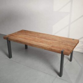 Beam Dining Table with a rectangular wooden top and sleek black metal legs, set against a plain background. Light and shadow patterns from a nearby window are visible on the floor and wall.