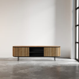 A contemporary Bolivar 2 Shelf TV Stand with sliding doors stands on a concrete floor in a minimalist room with a large window.