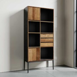 The Kolt Tall Display, a tall wooden shelving unit with a black frame, featuring multiple open compartments and closed drawers, stands in a well-lit room against a white wall.