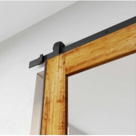 A Beveled Mirror Barn Door made from reclaimed wood, featuring a black metal track and stopper, is partially open against a white wall.