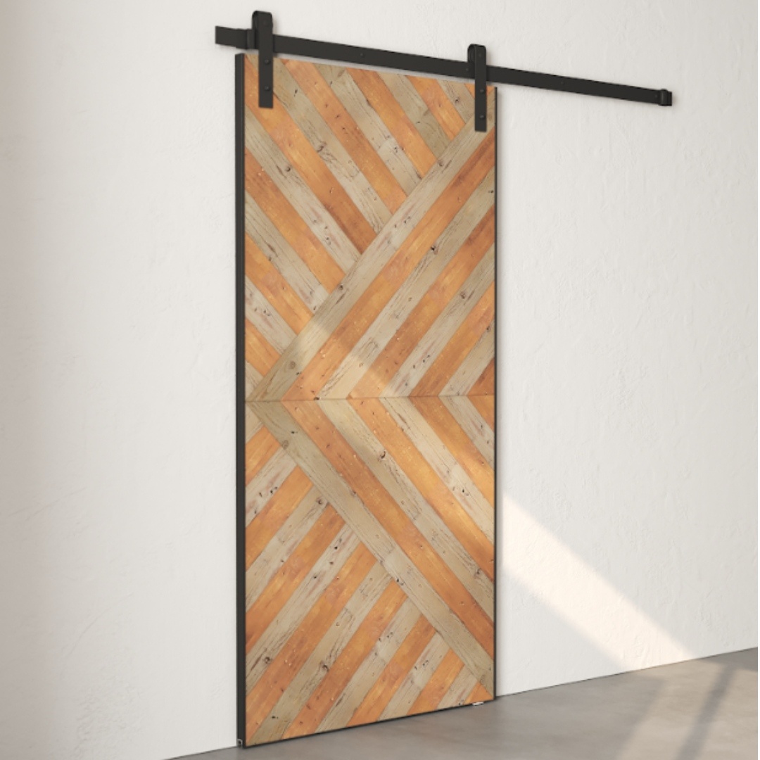 An Enigma Reclaimed Wood Barn Door Grey with a geometric wooden pattern on a black metal frame, mounted on a white wall. The door features diagonal planks forming a central X design.