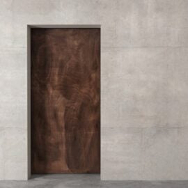 The Enigma Reclaimed Wood Barn Door Grey is set in a concrete wall, blending modern and natural design elements.