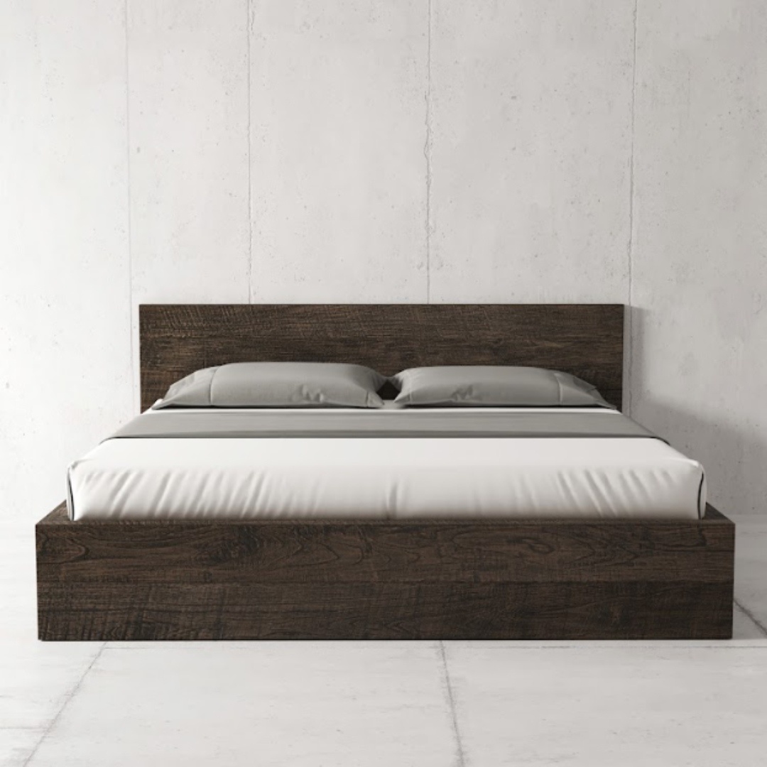The Lugano Bed in Café Noire, a modern platform bed with a headboard, features white bedding and two gray pillows, all set against a plain white wall.