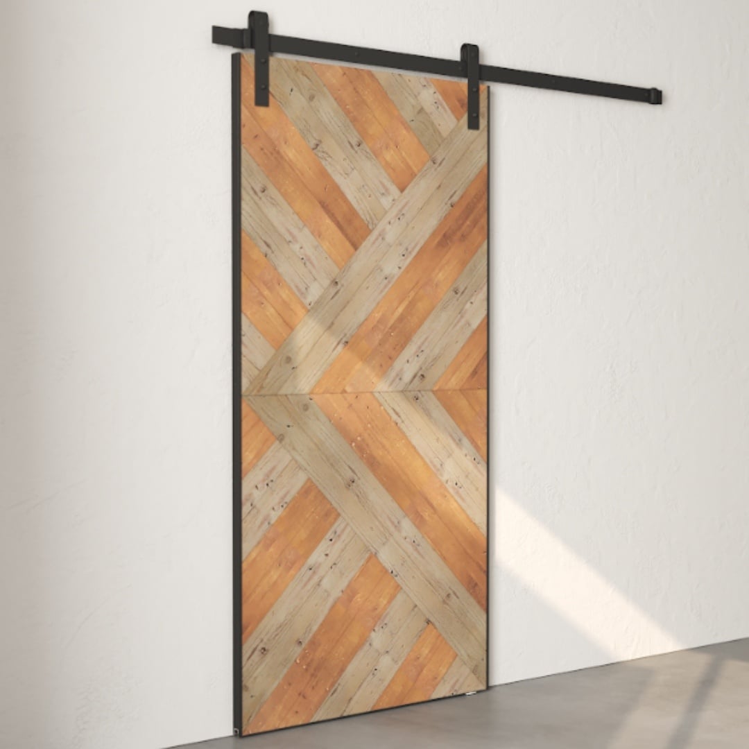 A sliding Reclaimed Wood Barn Door with diagonal wood paneling in a chevron pattern, mounted on a black metal track system against a plain white wall.