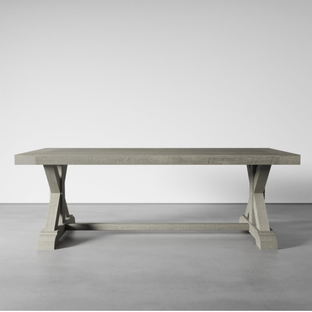 The Madera Dining Table - Rustic Grey, with its light gray wooden rectangular design and crossbar support, stands on a plain gray floor against a white background.