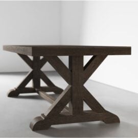 The Madera Dining Table - Café Noire, with its thick tabletop and two sturdy X-shaped leg supports, stands in a minimalist, light-colored room.