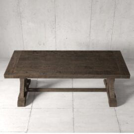 The Madera Dining Table - Café Noire, featuring a rectangular wooden design and sturdy legs, is set against a plain, light-colored, textured wall and tiled floor.