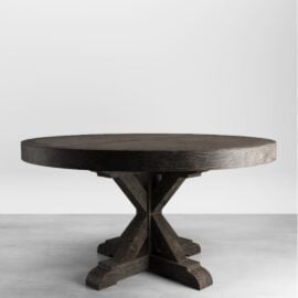The Madera Round Table boasts a dark finish and a sturdy, cross-shaped base, perfect for adding elegance to any space. It stands on a gray surface against a plain white background, making it an ideal centerpiece for your Café Noire.