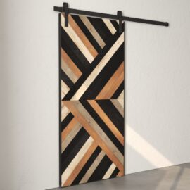 Introducing the Nomad Barn Door, a wooden sliding door featuring a striking geometric design in various shades of wood and black, mounted on a sleek black metal track against a pristine white wall.