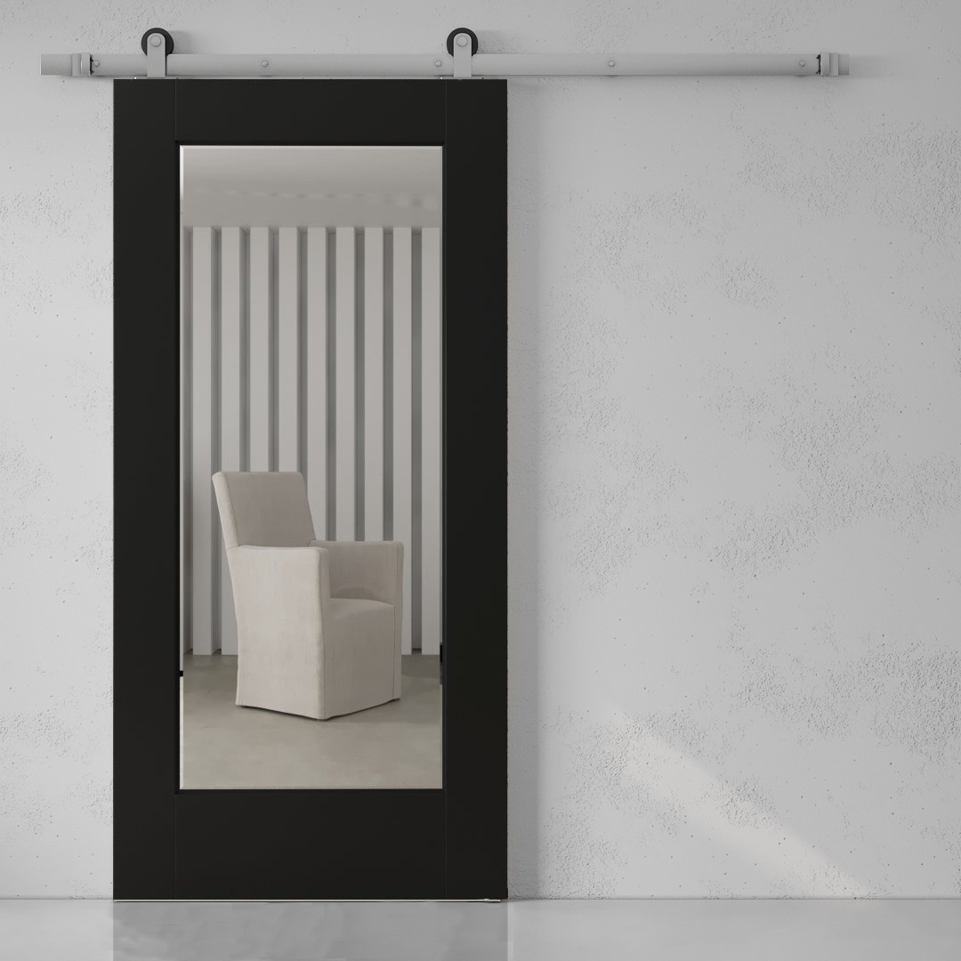 A minimalist room features a white upholstered chair visible through the Beveled Mirror Barn Door in Espresso, which reflects vertical striped wallpaper and a portion of the floor.