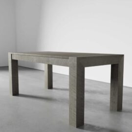 A Villa Dining Table - Rustic Grey with clean, modern lines stands on a smooth, grey floor in a room with plain white walls.