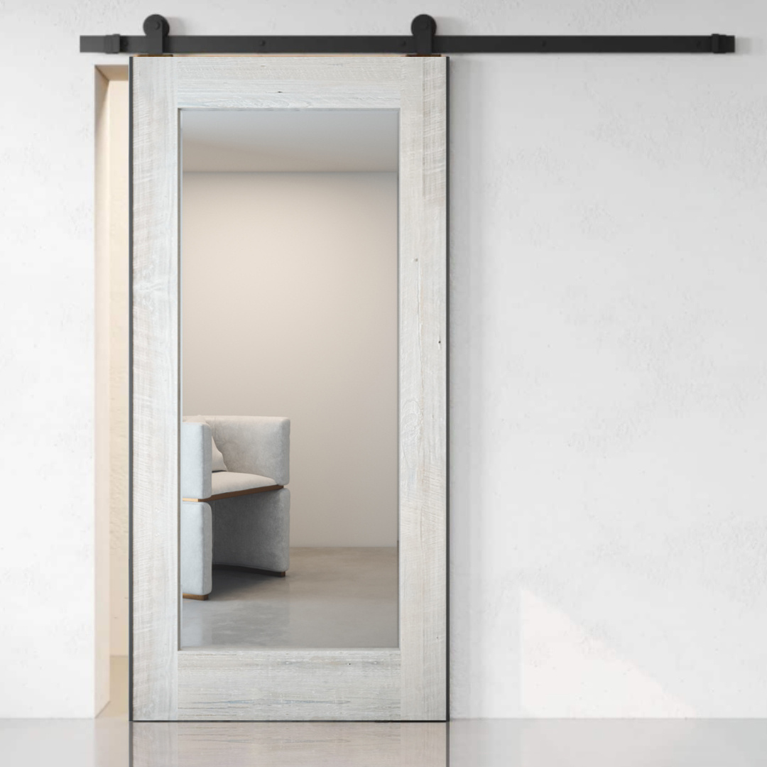 A Beveled Mirror Barn Door (White Wash) is partially open, revealing part of a light gray armchair against a plain, light-colored wall.