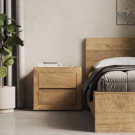 A modern bedroom scene featuring the Lugano Nightstand beside a bed with gray bedding. A potted plant is placed next to the nightstand, and a partial view of framed artwork is visible on the wall.