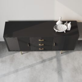 The Arista 60" Side Cabinet in black boasts sleek horizontal groove details, three central drawers with elegant golden handles, and two side cabinets. Atop the modern piece are a decorative white bowl and figurines.