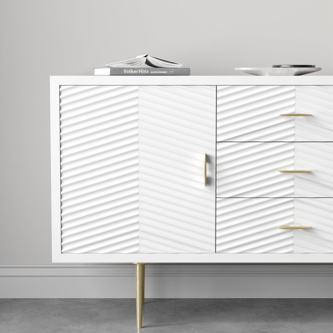 Arista 60_ Side Cabinet 2 The Arista 60" Side Cabinet in White Wash boasts a modern finish with textured doors, complemented by elegant gold legs and handles. Its spacious width makes it ideal for stylishly displaying items like a book or dish on top.