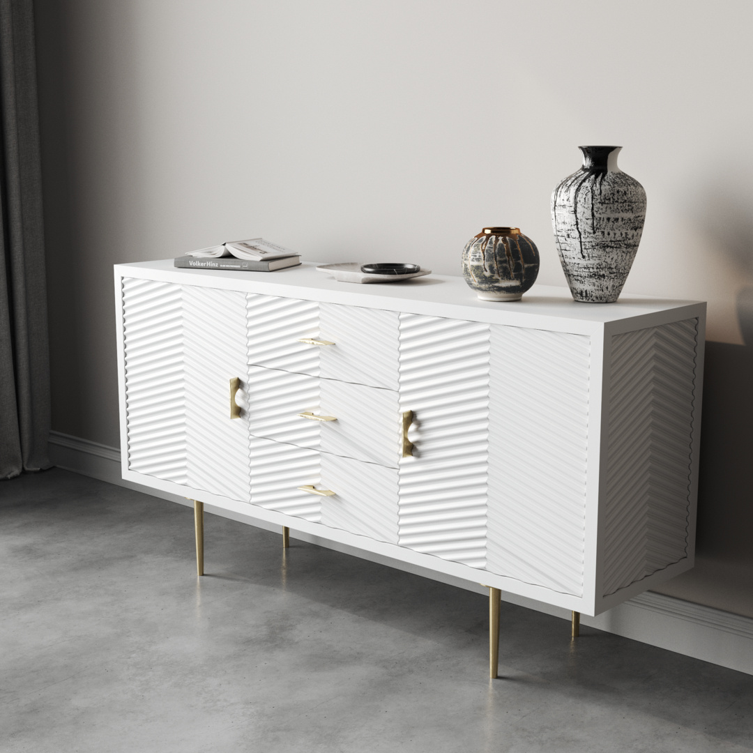 Arista 60_ Side Cabinet 4 An Arista 60" Side Cabinet in White Wash with textured doors and gold handles stands elegantly against a light-colored wall. It showcases two decorative vases and a stack of books, providing both style and functionality in this chic space.
