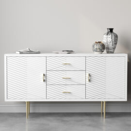 The Arista 60" Side Cabinet in its white wash finish features textured doors and gold handles, making it a stylish focal point. Accented with two vases and a book, it stands gracefully against a light gray wall, exuding sophistication.