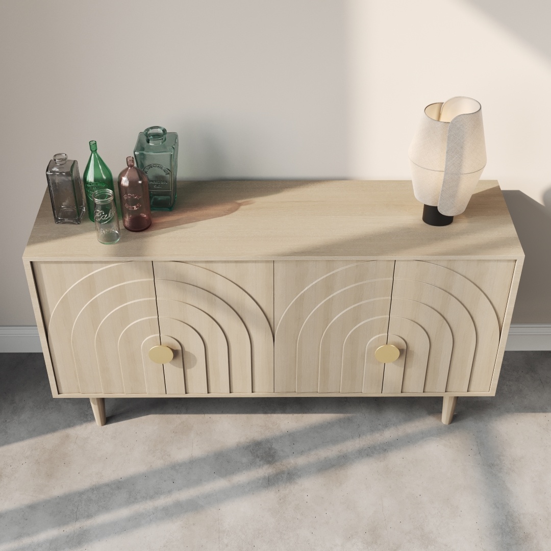 Azul 58 Side Cabinet-c The Azul 58" Side Cabinet, crafted from light wood and featuring two decorated doors, stands against a plain wall on a concrete floor. On top of the cabinet are three azul-colored glass bottles and a modern table lamp.