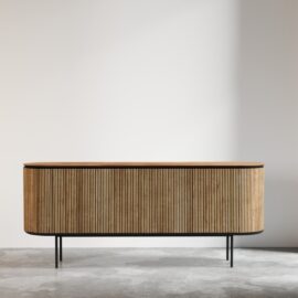 The Bolivar Dining Buffet, featuring a modern design with vertical wooden slats, a sleek black frame, and slender legs, stands against a plain light-colored wall in a minimalist room.