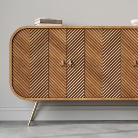 The Vista 60" Side Cabinet, adorned with a sophisticated chevron pattern and supported by stylish angled legs, is positioned against a gray wall with two decorative items elegantly displayed on top.