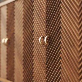 Close-up of the Vista 60" Side Cabinet featuring a wooden chevron pattern and two crescent-shaped metallic handles.