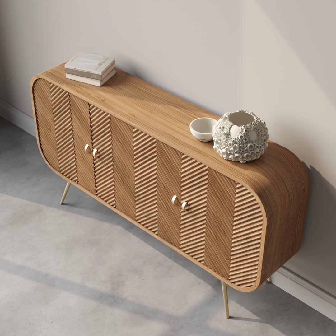 Vista 60 Side Cabinet-e The Vista 60" Side Cabinet is a wooden sideboard with a minimalist design, featuring vertical grooves, three cabinet doors, and angled legs. Its surface is adorned with a white vase, a bowl, and a few books.