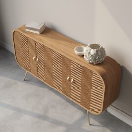 The Vista 60" Side Cabinet is a wooden sideboard with a minimalist design, featuring vertical grooves, three cabinet doors, and angled legs. Its surface is adorned with a white vase, a bowl, and a few books.