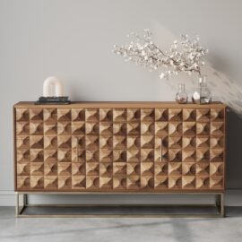 The Wadi 57" Side Cabinet, featuring modern wooden construction with geometric patterns, displays a decorative branch in a vase, two glass bottles, and a small lamp against a gray background.