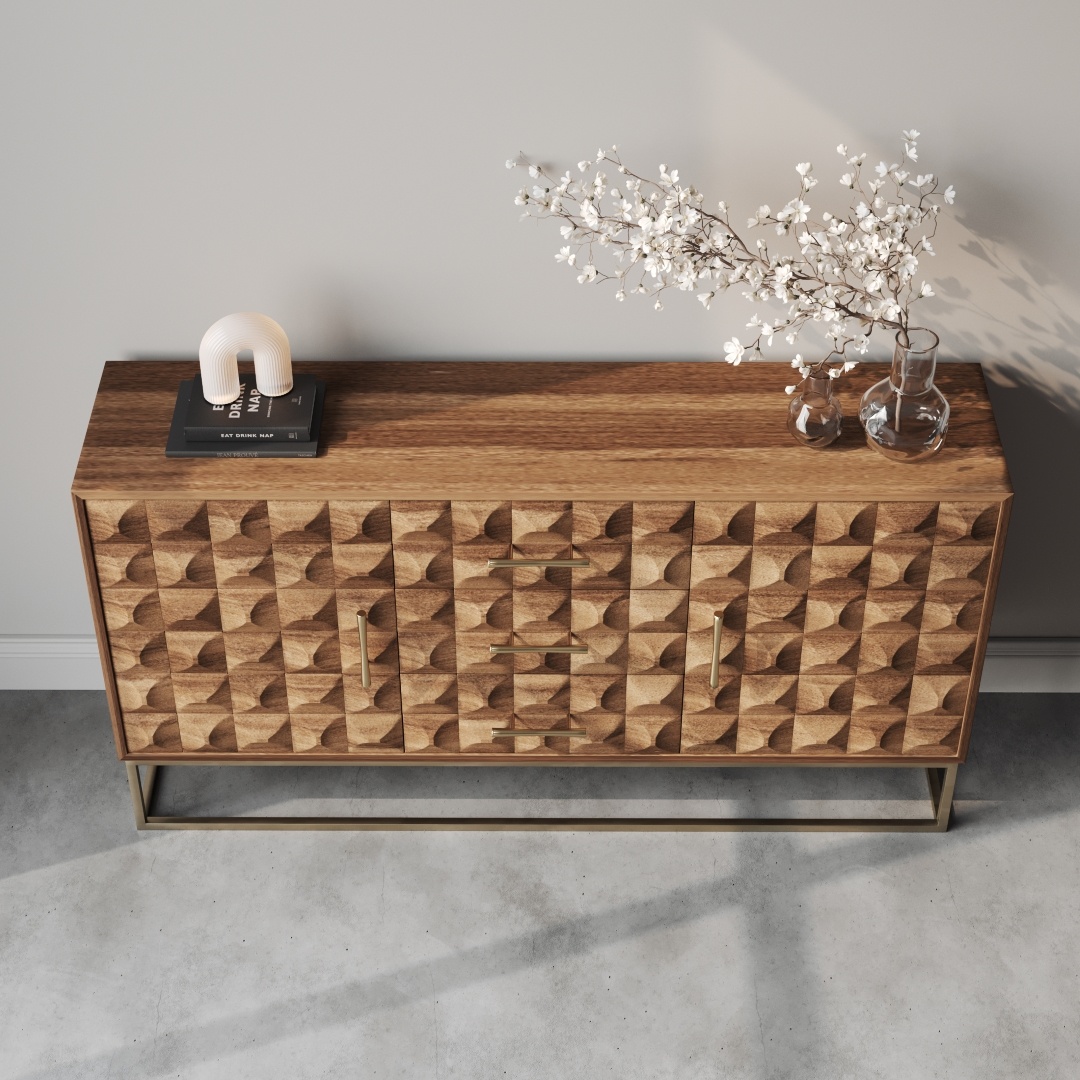 Wadi 57 Side Cabinet-d The Wadi 57" Side Cabinet, featuring a geometric pattern and made of wood, stands against a light wall. It is topped with a white lamp, a book, and a vase holding branches with white flowers. The floor appears concrete.