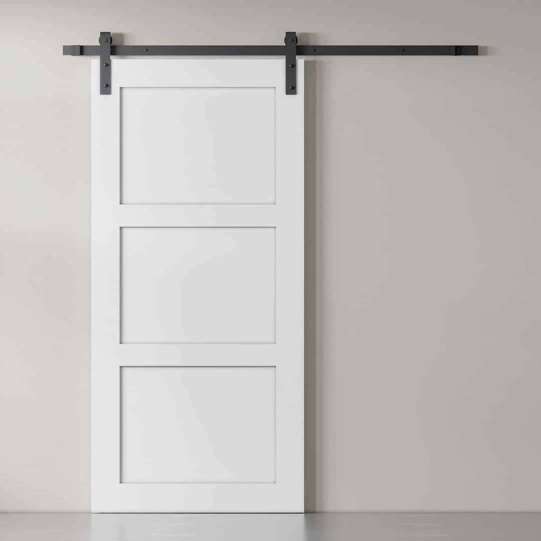 3-Panel-White-1.jpg The 3-Panel Barn Door, finished in white, is mounted on a black sliding track and positioned against a light gray wall.