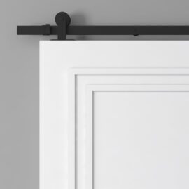Partial view of the Atelier Barn Door, featuring black sliding barn door hardware, mounted on a gray wall.